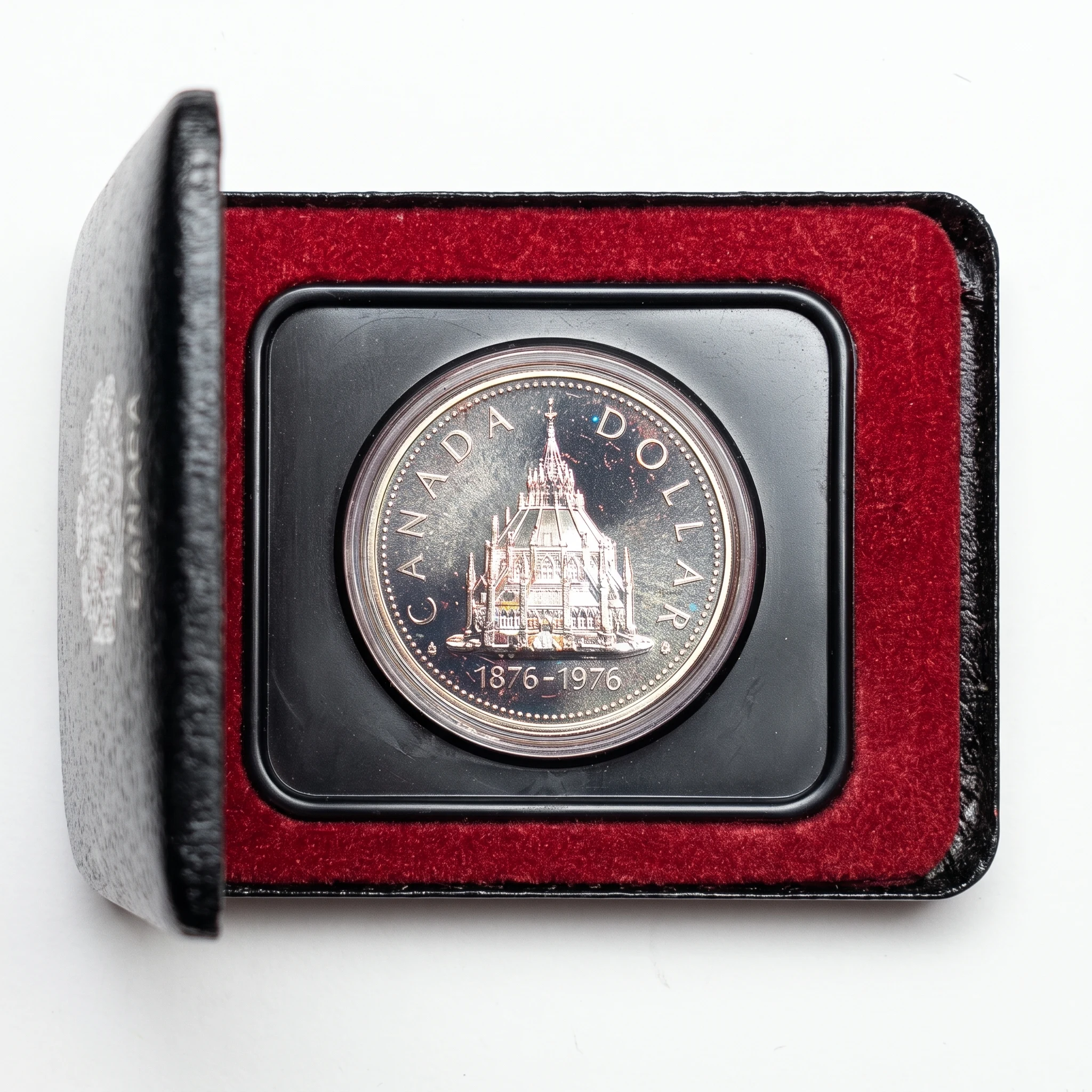 1976 Library of Parliament silver dollar in its case, reverse, with rainbow toning