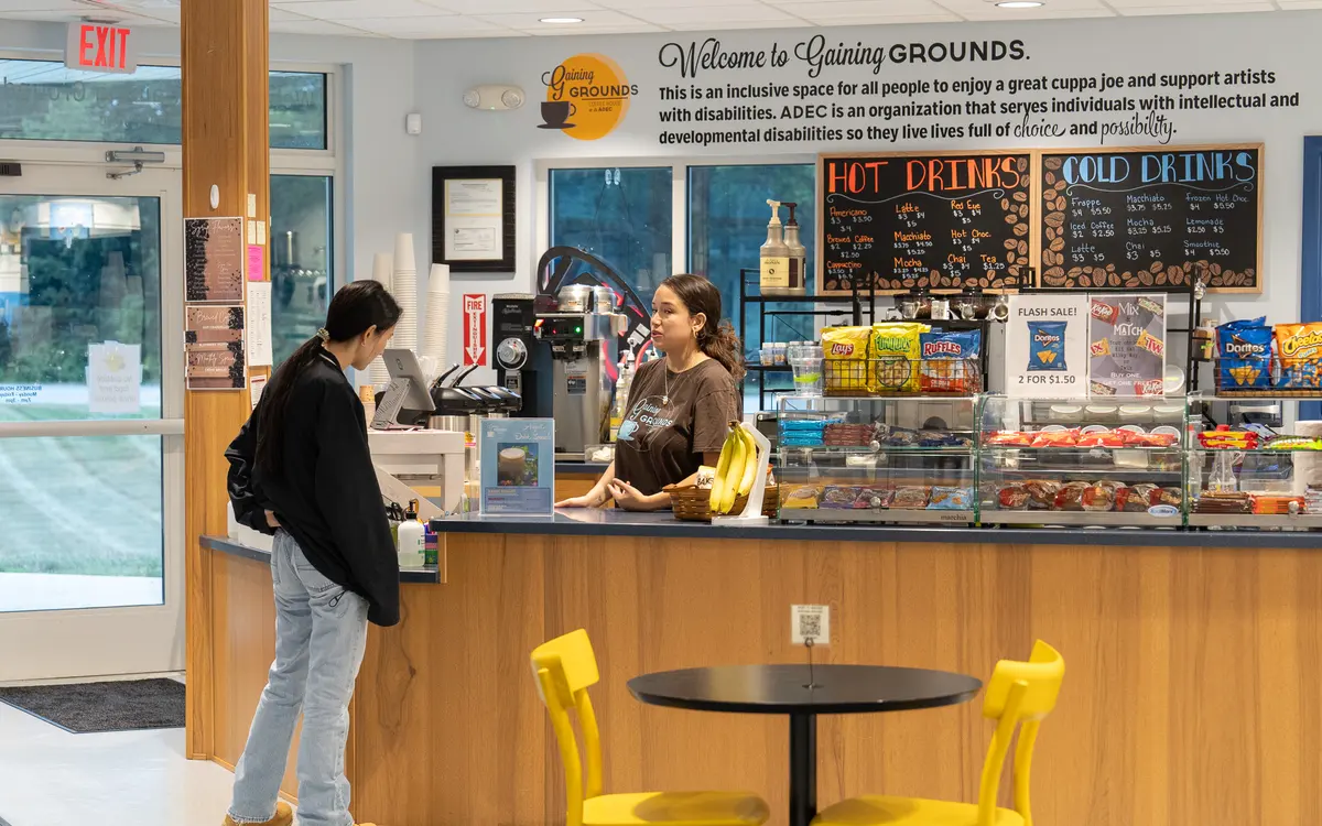 Staff and customer interacting at the Gaining Grounds Coffee House counter