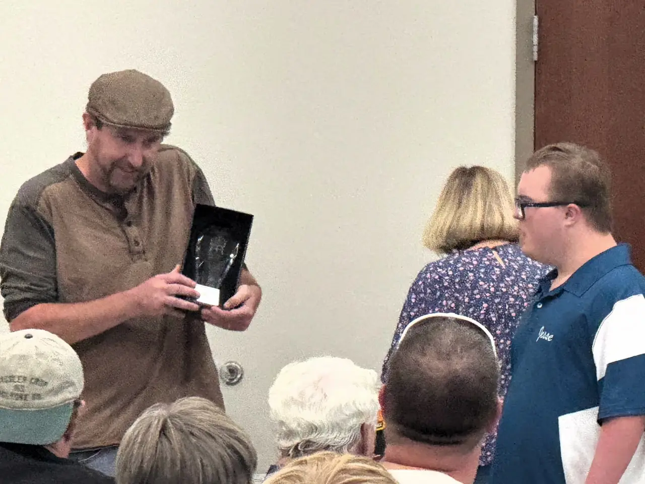 Attendees at an Arc of Northeast Colorado gathering as a man holds up an award
