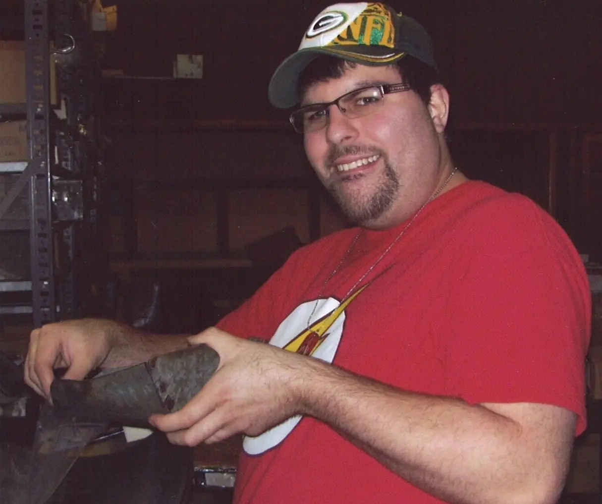A participant smiling at the camera while working in a workshop