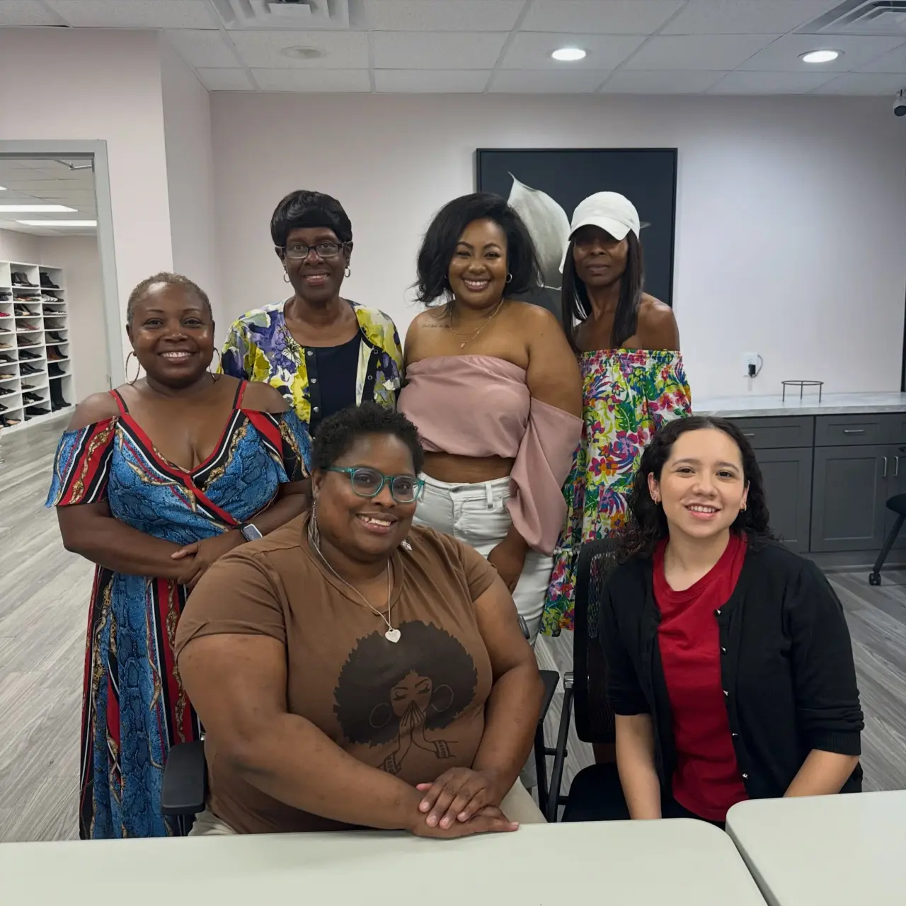Six women seated and standing together in the EmpowHER center