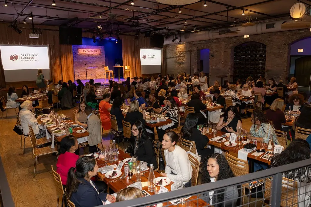 Guests seated at long tables in an event hall at a Dress for Success Greater Chicago luncheon