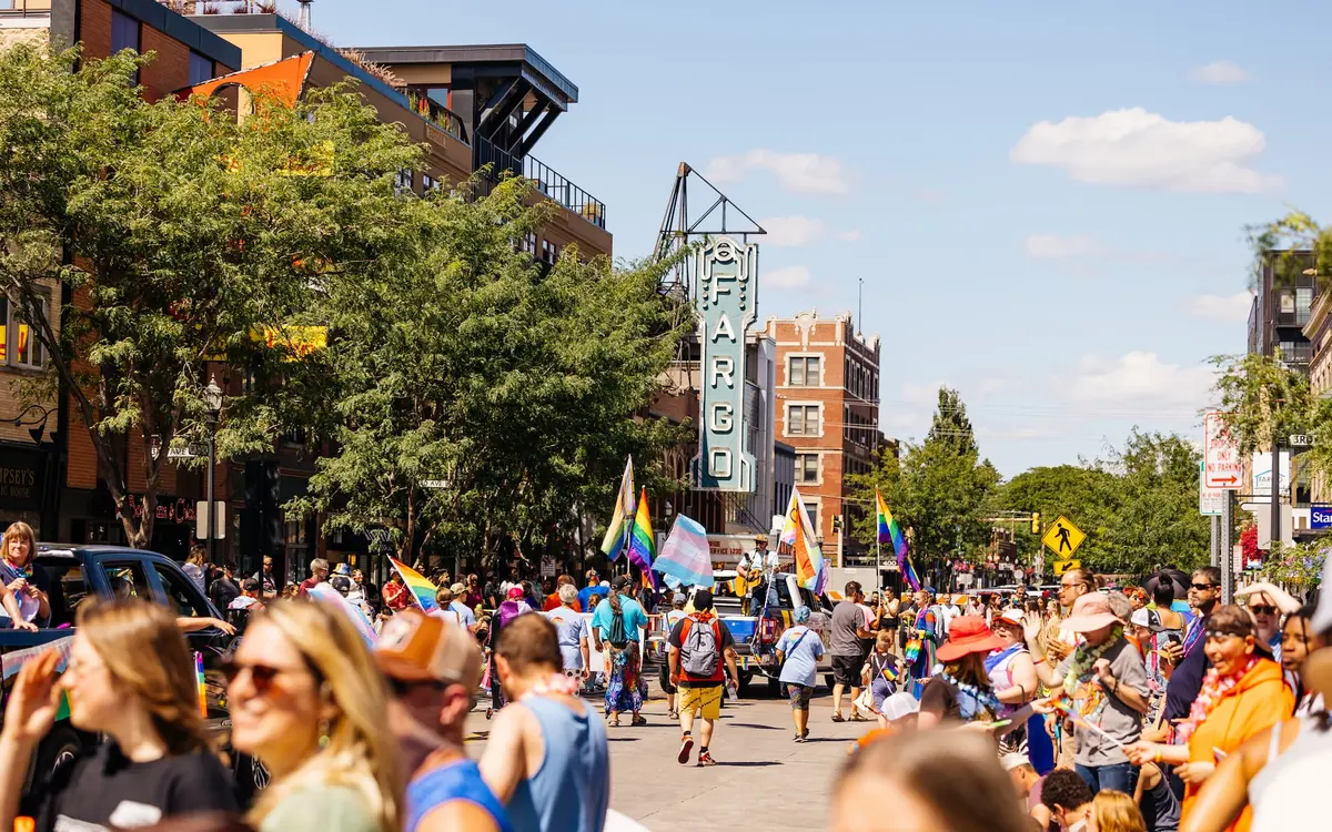 Community crowd and parade participants celebrating FM Pride on Broadway in front of the Fargo Theatre