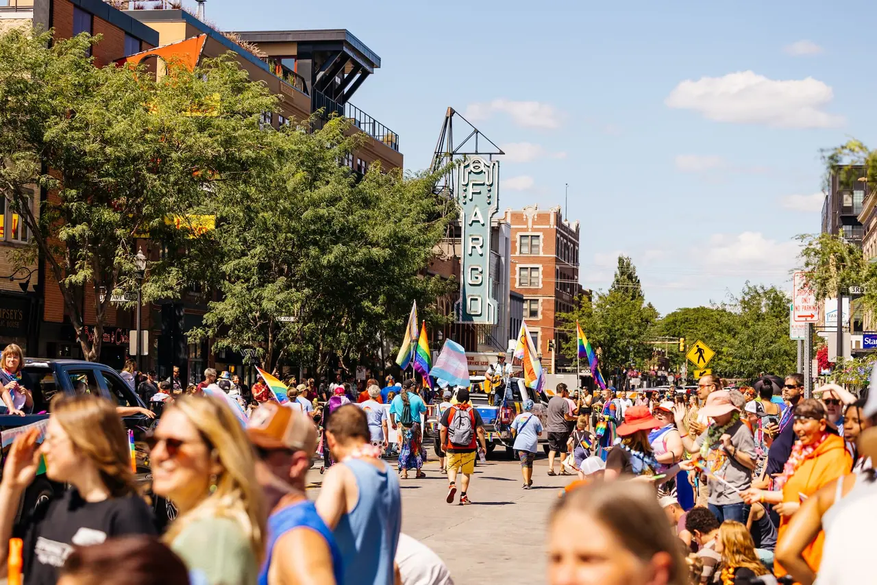 Community crowd and parade participants celebrating FM Pride on Broadway in front of the Fargo Theatre