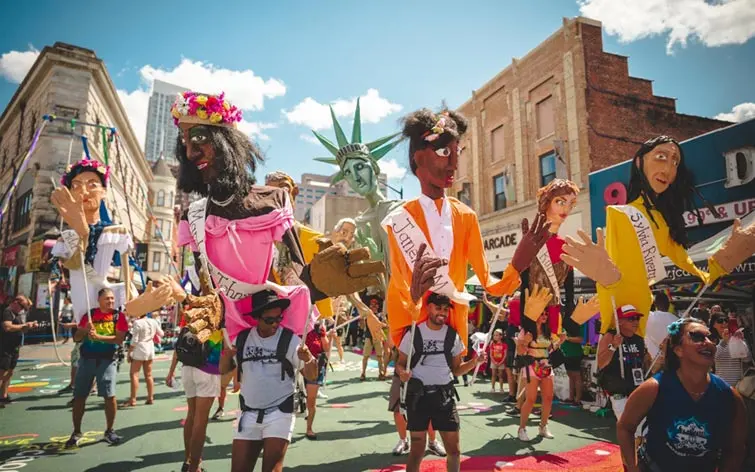 Participants and large puppet figures marching during the Jersey City Pride parade