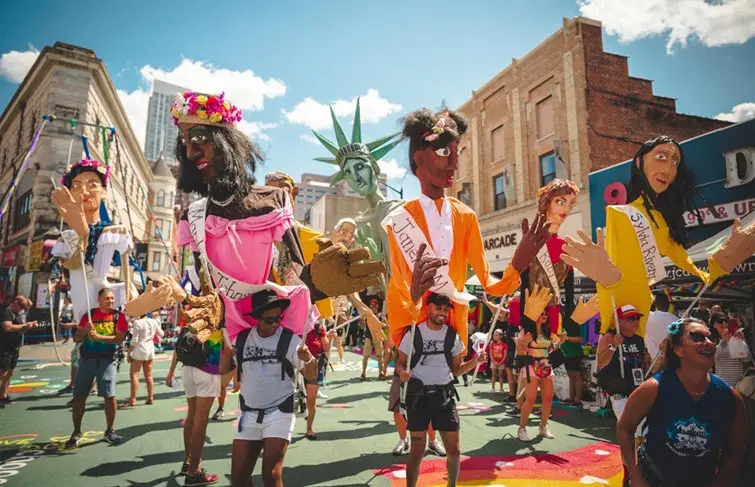 Participants and large puppet figures marching during the Jersey City Pride parade