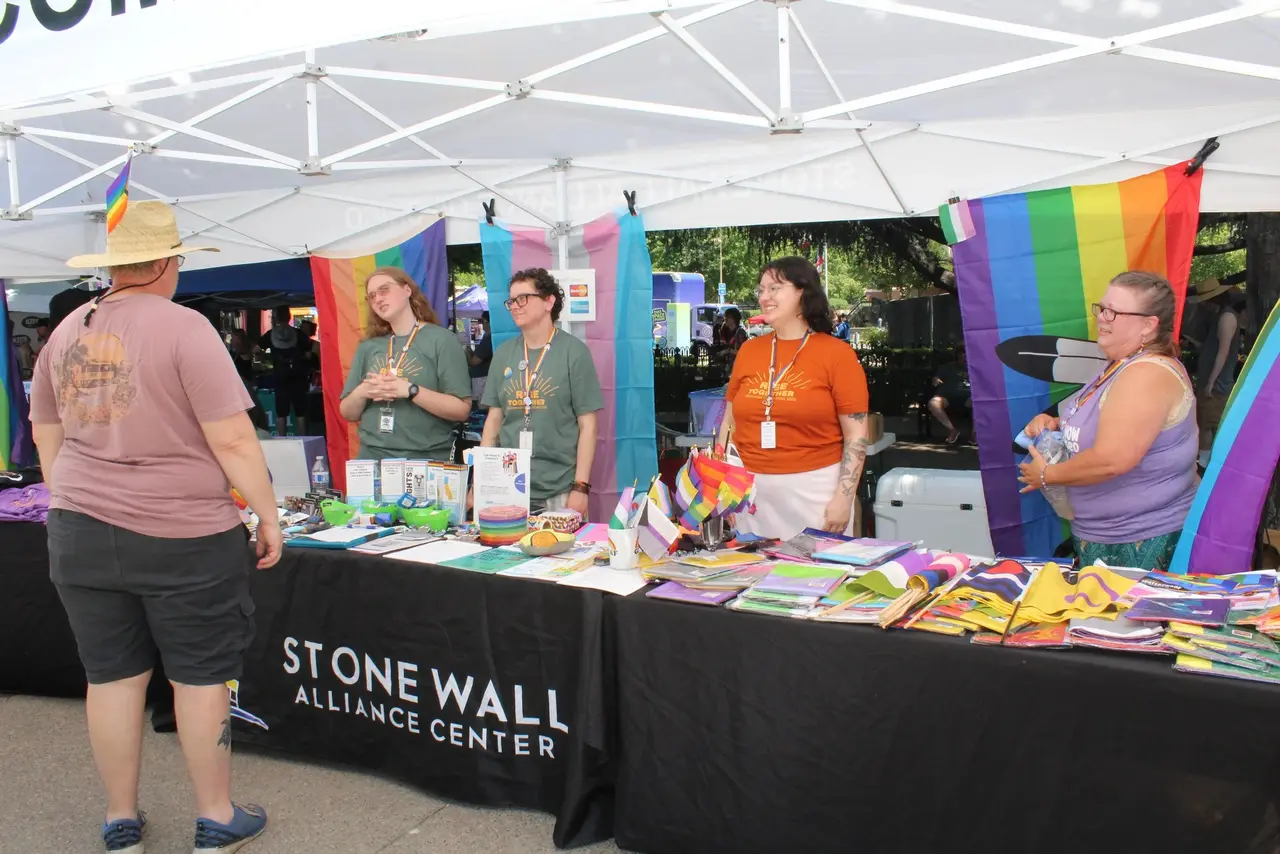 Staff and volunteers at the Stonewall Alliance Center table at a Chico Pride festival