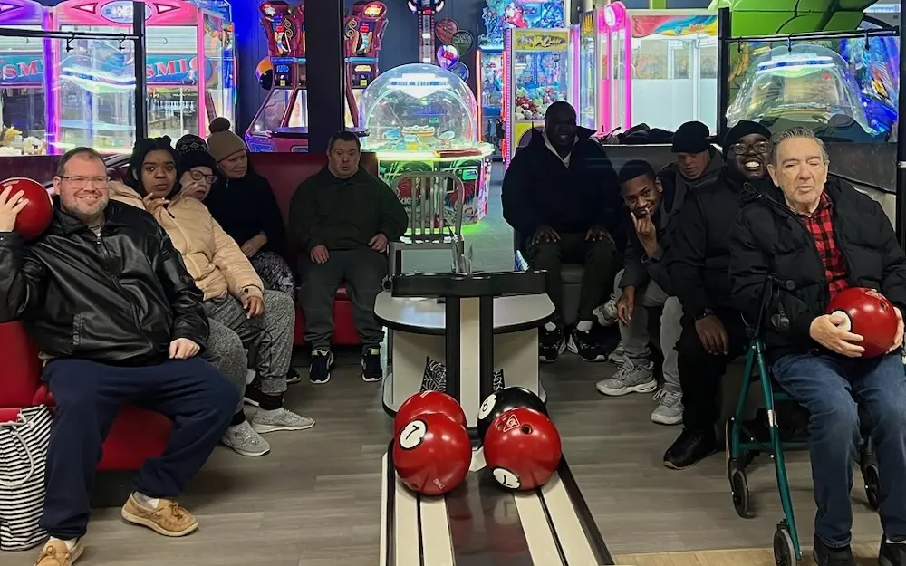 Day habilitation participants enjoying a bowling outing together