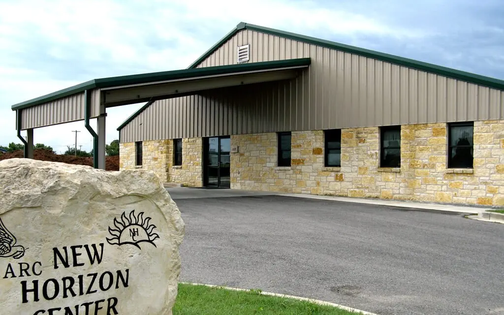 Stone entrance marker and exterior of the New Horizons Center on Industrial Loop in Fredericksburg