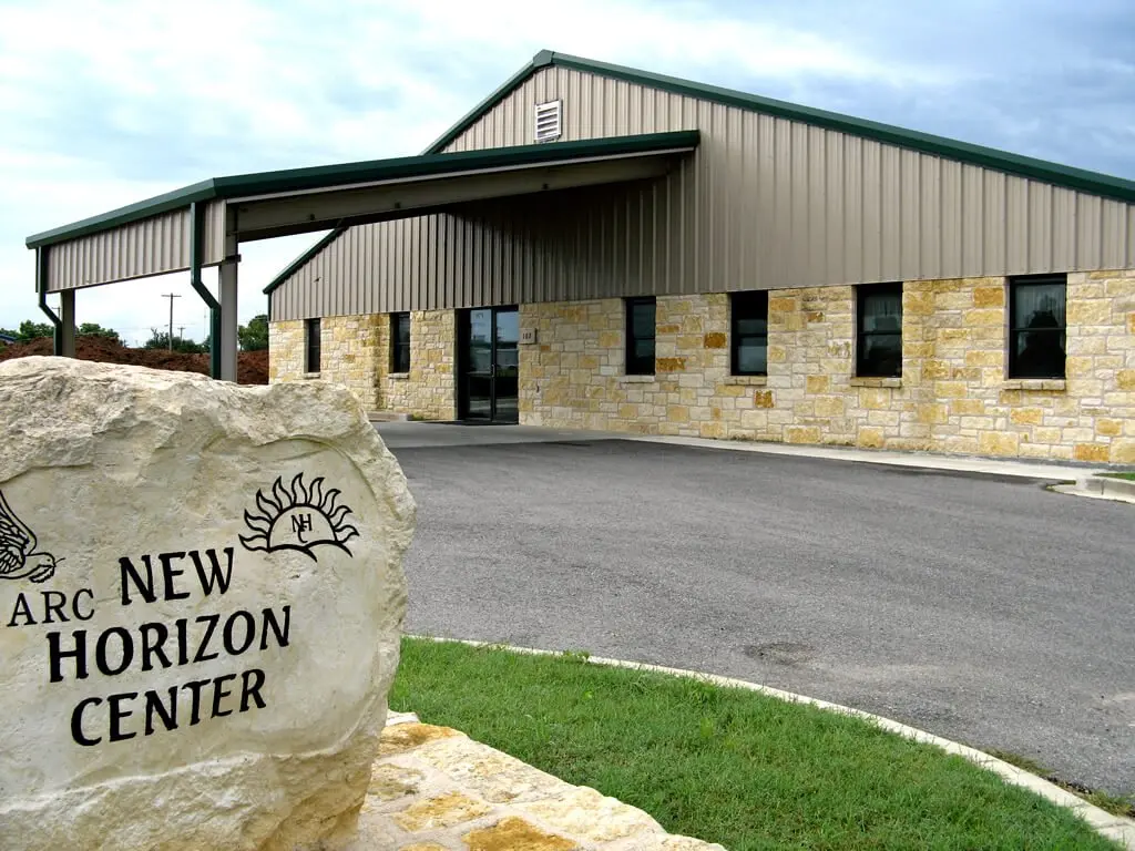 Stone entrance marker and exterior of the New Horizons Center on Industrial Loop in Fredericksburg