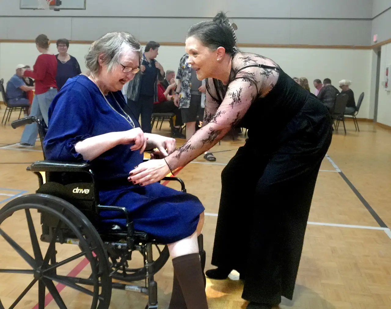 Participant in a wheelchair dancing with a partner at an Arc of Haywood County celebration