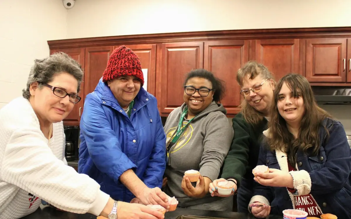 Program participant and support specialist baking together in a community kitchen