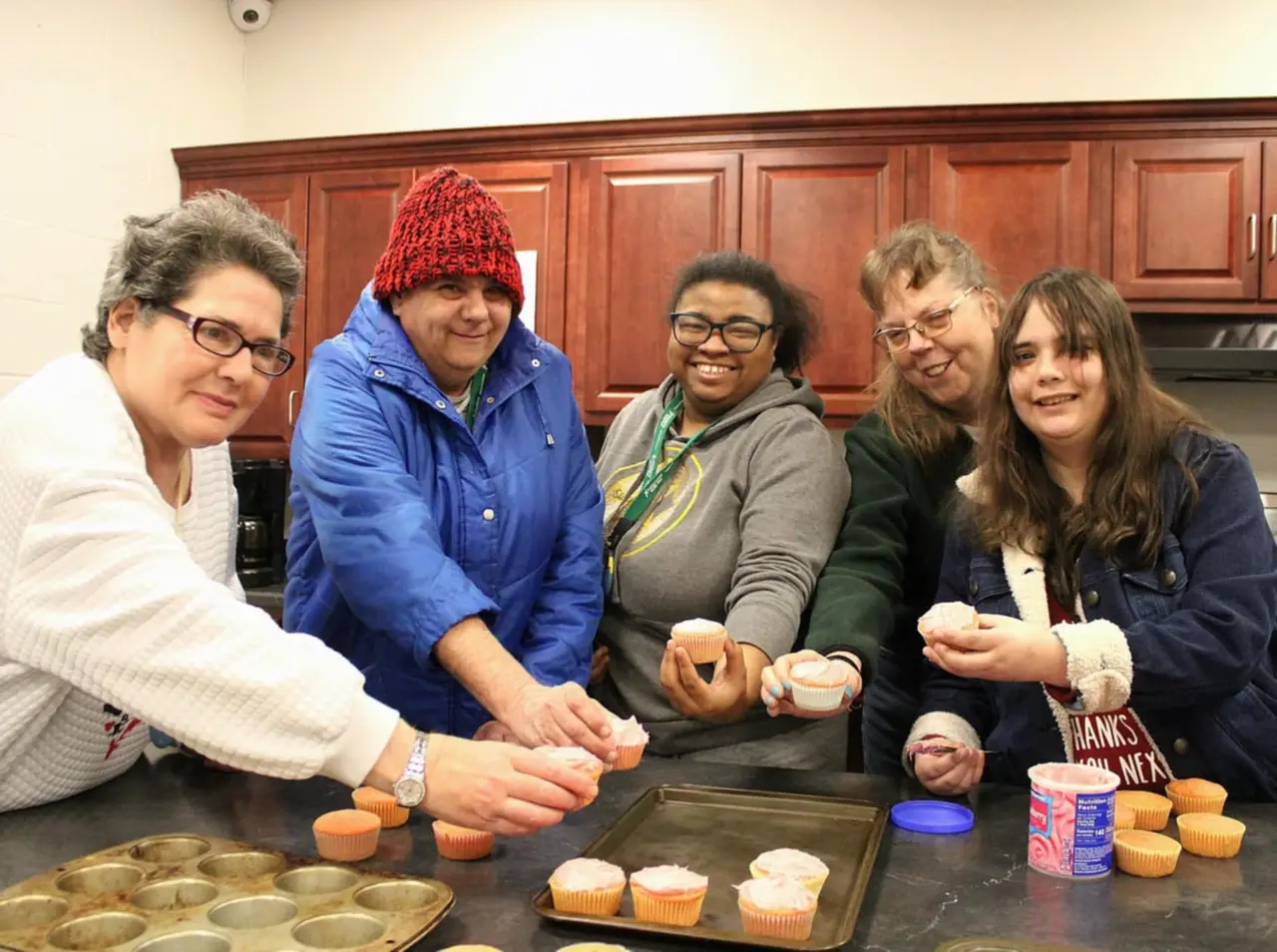 Program participant and support specialist baking together in a community kitchen