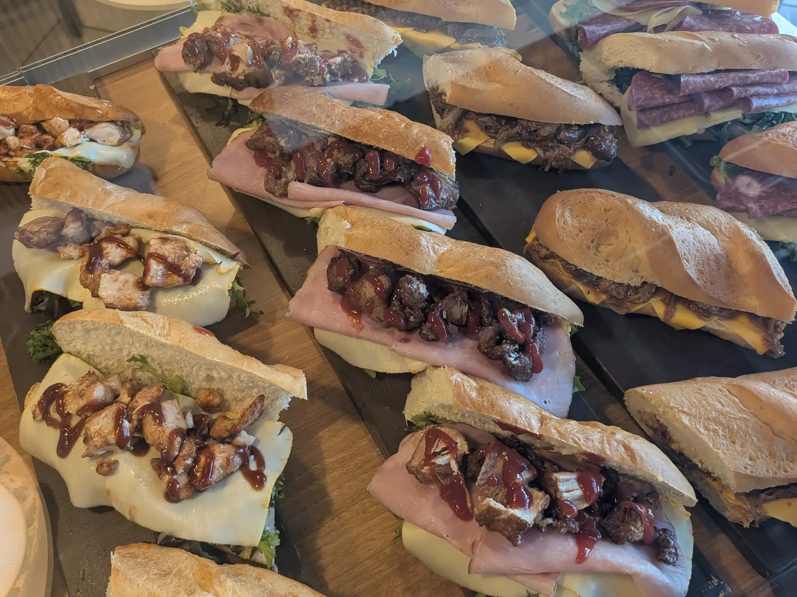 The sandwich case at Tico's Bakery in Tampa, rows of rolls layered with ham, cheese, chicken and pulled pork