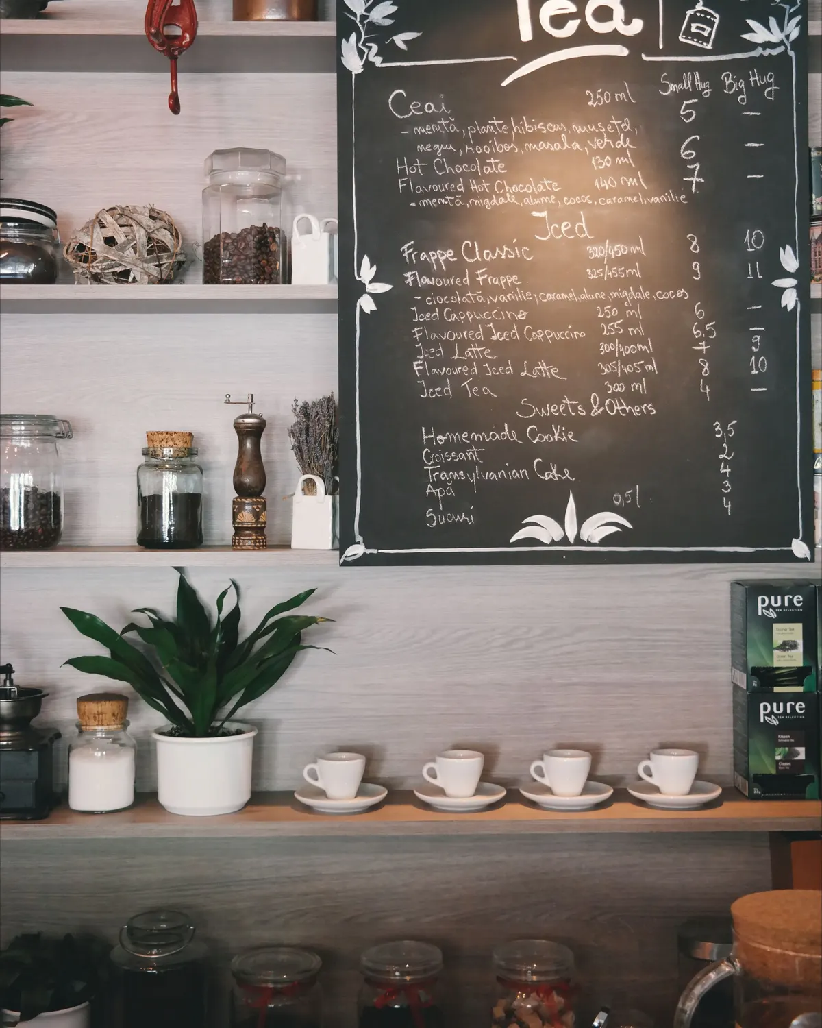 A chalkboard cafe menu with drinks and prices hand-lettered in small script